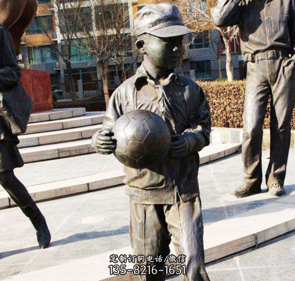 广场摆放拿足球的小学生人物铸铜雕塑
