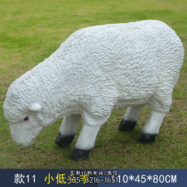 草地上一只低头的玻璃钢仿真绵羊雕塑