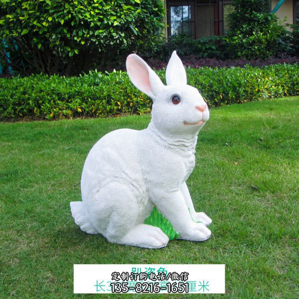 景区草坪中一只白色玻璃钢兔子雕塑