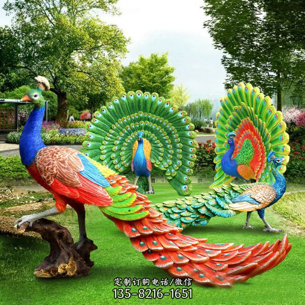 草坪上摆放着一对绚丽双孔雀雕塑，它们拖着精美的尾巴…